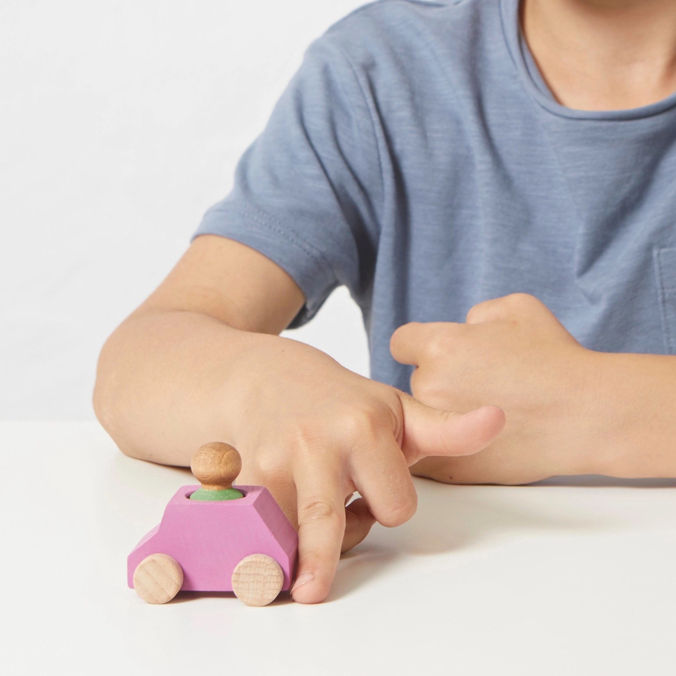 Pink wooden car with green figure